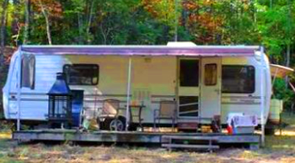 Inhabited Camper with Added Porch Under Overhang