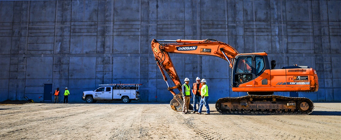 Excavator at a Construction Site in Front of a Wall